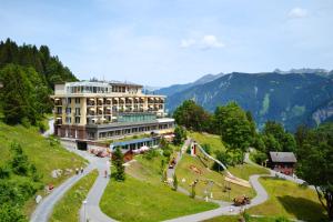 a building on a hill next to a road at Märchenhotel in Braunwald