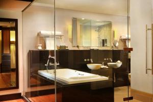 a bathroom with a tub and a sink and a mirror at Dusit Thani Laguna Phuket in Bang Tao Beach