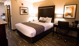 Habitación de hotel con cama, escritorio y escritorio. en Ten Pin Inn & Suites, en Moses Lake