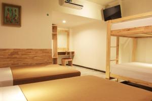 a room with two bunk beds and a television at Hotel Karthi Kuta in Kuta