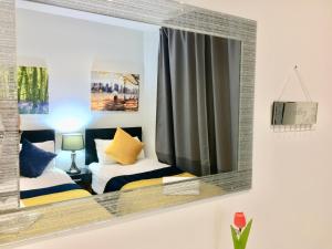 North WoolwichにあるLondon ExCel 2 Bedrooms River View Apartmentの鏡付きのベッドルーム(ベッド2台付)