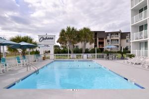 
a swimming pool with a pool table and chairs at Cabana Shores Hotel in Myrtle Beach
