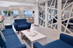 - un salon avec des chaises bleues et une table dans l'établissement Cabana Shores Hotel, à Myrtle Beach