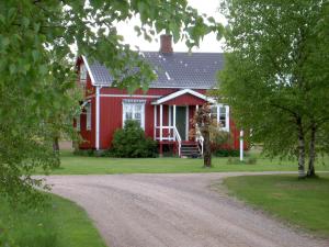 a red house with a dirt road in front of it at Holms Heagård in Halmstad