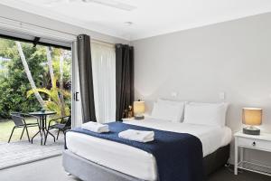 
a bedroom with a bed and a dresser at The Park Hotel Motel, Byron Bay in Byron Bay
