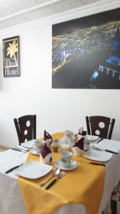 a dining room table with a yellow table cloth and chairs at Hotel Palma de la Sabana in Bogotá