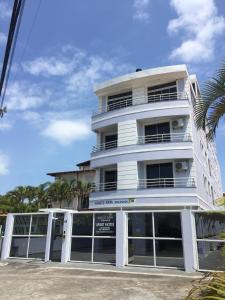 um edifício branco com um sinal em frente em Kasato Maru Residence em Florianópolis