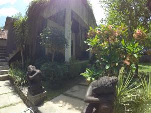 a garden with statues in front of a building at Rumah Made in Amed +11 photos