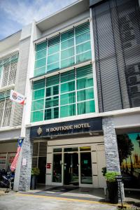 un edificio con un hotel boutique di fronte ad esso di H Boutique Hotel Sri Petaling a Kuala Lumpur