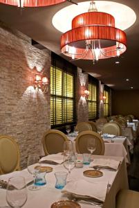 restauracja z białymi stołami i krzesłami oraz żyrandolem w obiekcie Coto Real w mieście Rábade