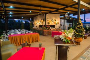 einen Bankettsaal mit roten und gelben Tischen und Weihnachtsbäumen in der Unterkunft Good Night Pool Villa Phuket - SHA Plus in Phuket