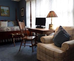 a living room with a desk with a computer and a couch at Strickland Arms Bed and Breakfast in Austin