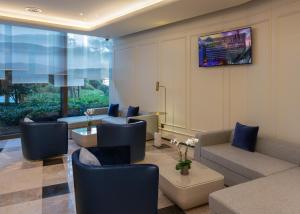 a living room with a couch and a table and chairs at Barony Park Hotel Shanghai in Shanghai