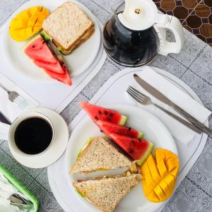 a table with two plates of sandwiches and a cup of coffee at Hadassah’s Place in Olango Island