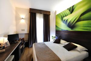 a bedroom with a bed with a large painting on the wall at Hotel Life in Rimini