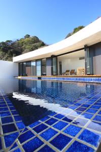 una casa con piscina rivestita di piastrelle blu di Umito Voyage Atami ad Atami