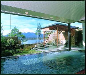 a swimming pool in a house with a view of a mountain at Shuhokaku Kogetsu in Fujikawaguchiko