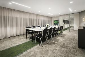 a conference room with a long table and chairs at Quest Canberra City Walk in Canberra