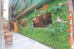 een groene muur met bloemen en planten erop bij Back Inn in Lukang
