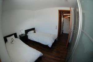 1 dormitorio con 2 camas y espejo en Ayoba, en Wiler
