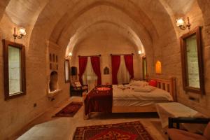 a bedroom with a bed in a stone room at Abu Hayat Cave Suites in Ortahisar