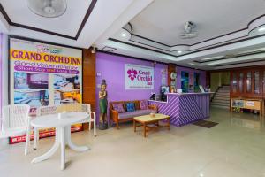 een kamer met een bank en een tafel en stoelen bij Grand Orchid Inn Patong beach in Patong Beach