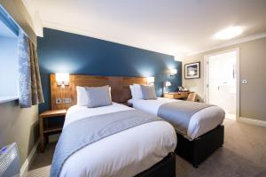Habitación de hotel con 2 camas y pared azul en Toby Carvery Beckenham by Innkeeper's Collection en Bromley