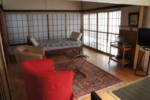 un soggiorno con divano e 2 sedie di EMS Enoshima ゲストハウス PetOK a Fujisawa