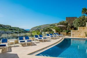 a swimming pool with lounge chairs and a swimming poolvisorvisor at Viewpoint Boutique Living in Xlendi