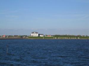 a house on the shore of a large body of water at Haus-Halligblick-Ferienwohnung-Groede in Dagebüll