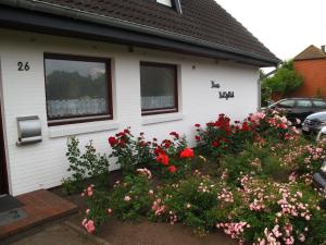 uma casa com um ramo de flores à frente dela em Haus-Halligblick-Ferienwohnung-Groede em Dagebüll