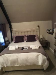 a bedroom with a large bed with two pillows at The Tanners Arms in Devynock