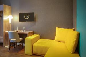 a room with a yellow couch and a table at Monopol Boutique Hotel in Bremen