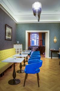 a row of tables with blue chairs in a room at Monopol Boutique Hotel in Bremen