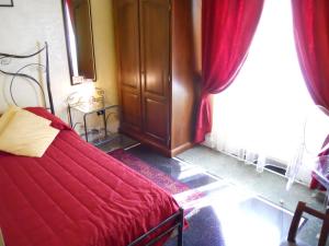 a bedroom with a red bed and a window at Locanda Villa Moderna in Genoa