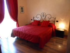 a bedroom with a red bed with a red blanket at Locanda Villa Moderna in Genoa