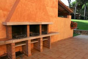 a patio with an orange wall with an outdoor fireplace at Casas Golf Relax in Pals