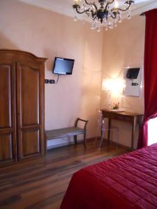 a bedroom with a bed and a desk and a television at Locanda Villa Moderna in Genoa