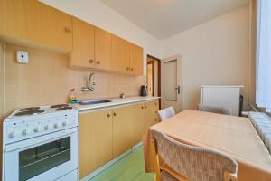 uma cozinha com uma mesa, um fogão e um frigorífico em Apartmany Firn em Pec pod Sněžkou