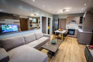 a living room with a couch and a table and a kitchen at Panorama Edge in Peyia