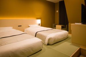 una camera d'albergo con due letti e una televisione di Tosei Hotel Cocone Ueno a Tokyo