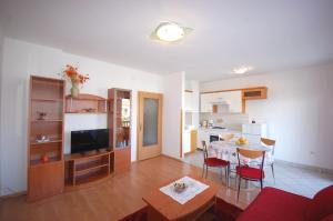 een woonkamer met een eettafel en een keuken bij Apartments Andrea in Njivice