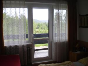 een slaapkamer met een raam met uitzicht op een veranda bij Willa Agata in Karpacz