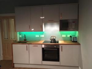 a kitchen with white cabinets and a tea kettle on the counter at Hopetoun Haven in Gullane