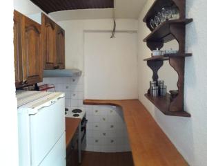 a kitchen with wooden cabinets and a white refrigerator at Apartmani Etno in Jahorina