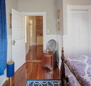 a bedroom with a bed and a wooden floor at 416A Waldburg st · Newly Renovated 1920's Historic District Apt in Savannah