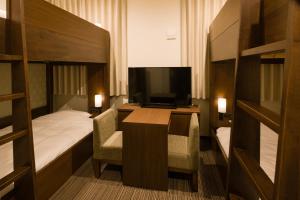 a hotel room with a desk and a bed and a television at Tosei Hotel Cocone Ueno in Tokyo