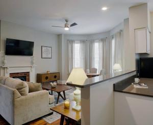 a living room with a kitchen and a living room with a couch at 414B Waldburg st · 2 Bedroom Oasis near Forsyth Park in Savannah