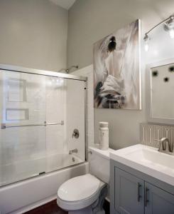 a bathroom with a shower and a toilet and a sink at 416A Waldburg st · Newly Renovated 1920's Historic District Apt in Savannah