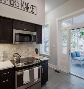 a kitchen with a stove and a microwave at 420Waldburg A · Modern Apt with Southern Charm Blocks from Forsyth in Savannah